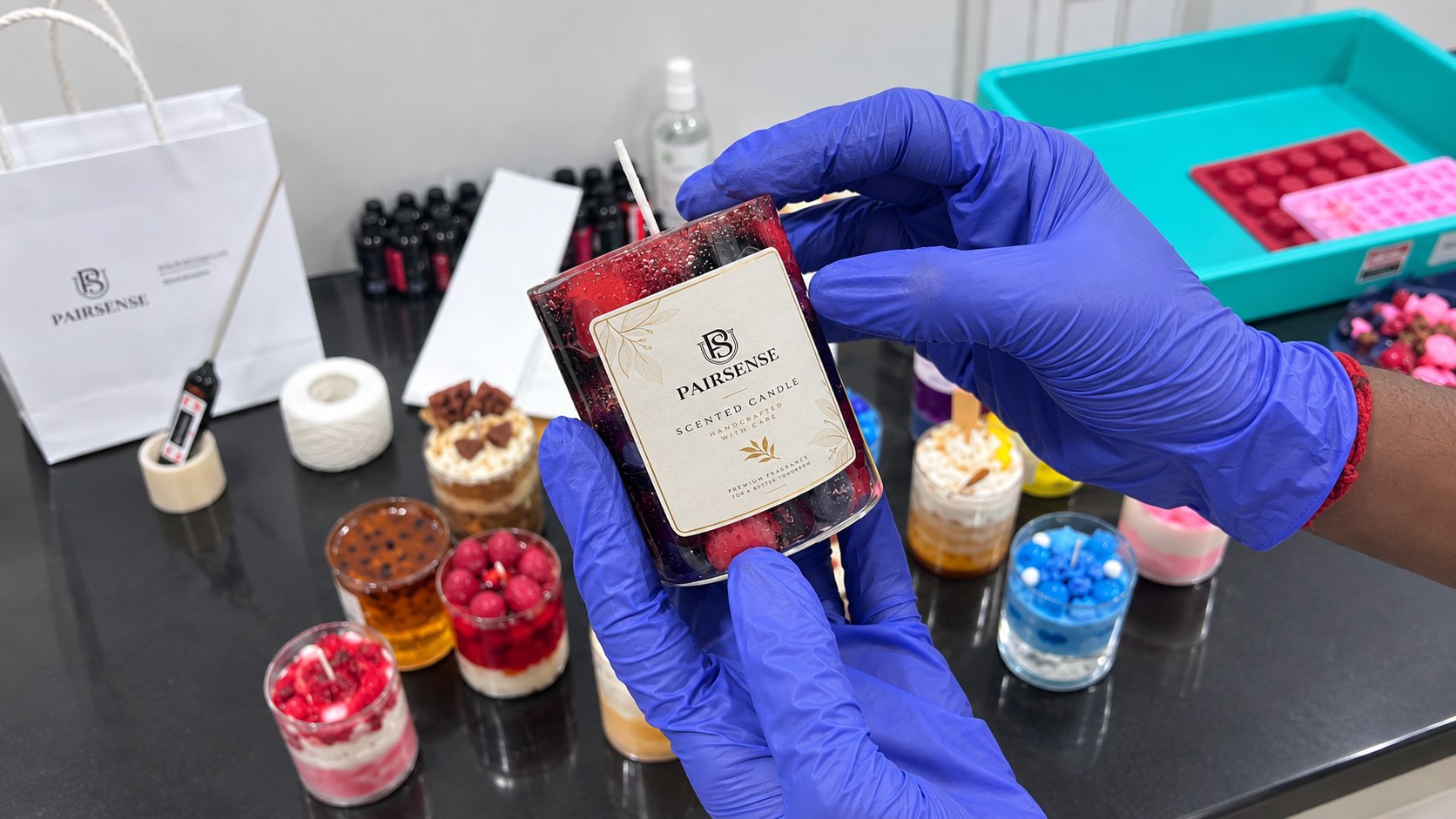A finished berry candle being labelled by hand in the Pairsense lab