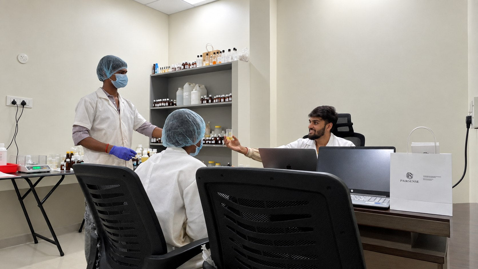 A Pairsense perfumer handing a trial vial across the bench to a colleague for review
