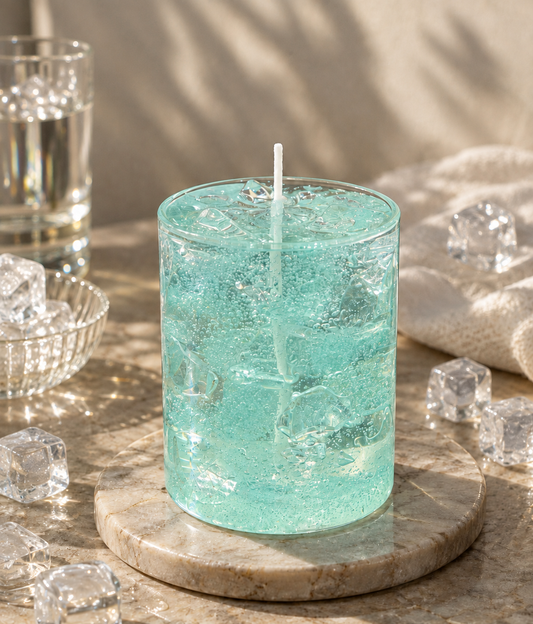 Pairsense Iced Aqua scented candle, clear aqua gel with crushed ice and bubbles in a glass tumbler, on a marble coaster surrounded by ice cubes