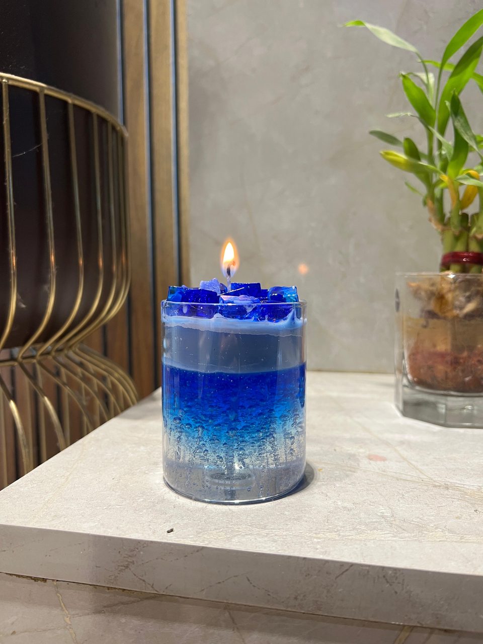 A customer's Pairsense Blue Crystal candle, blue crystals over layered blue gel, lit on a marble shelf