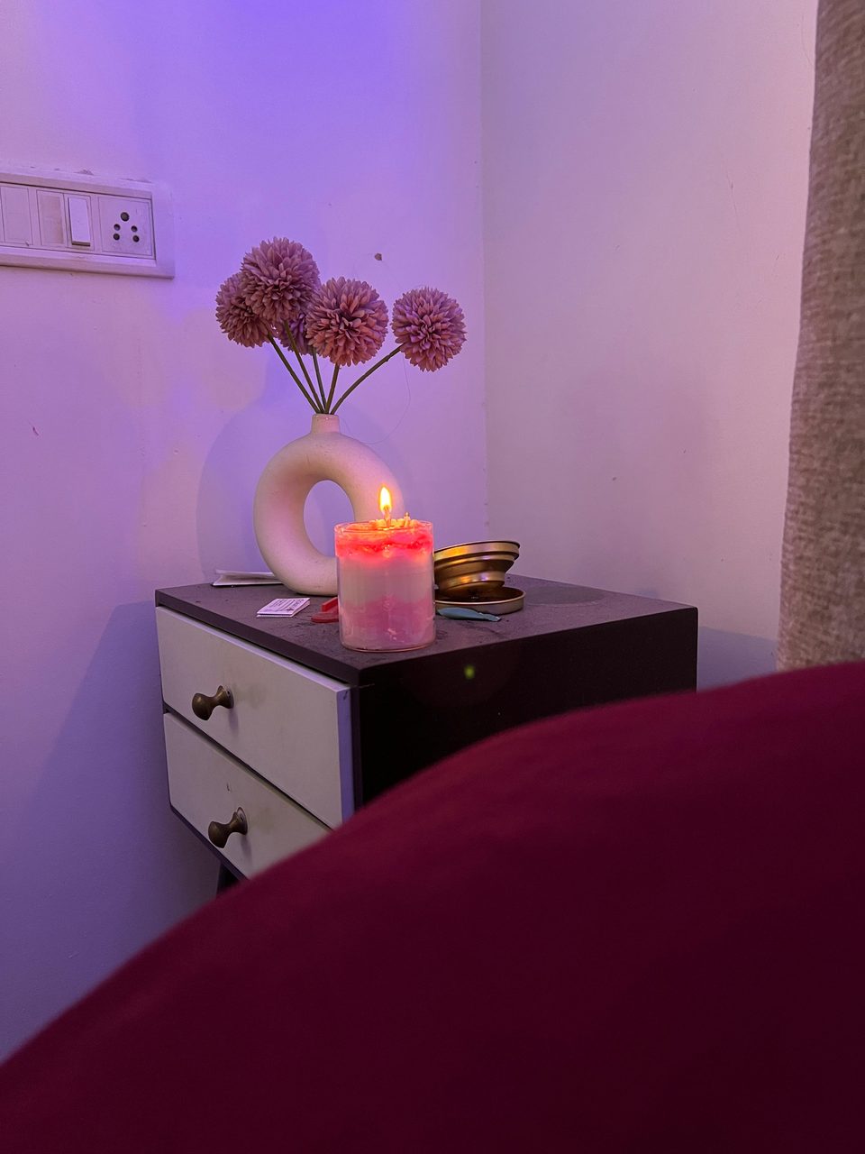 A customer's Pairsense Rose Poudré candle lit on a bedside table, its rose top glowing pink